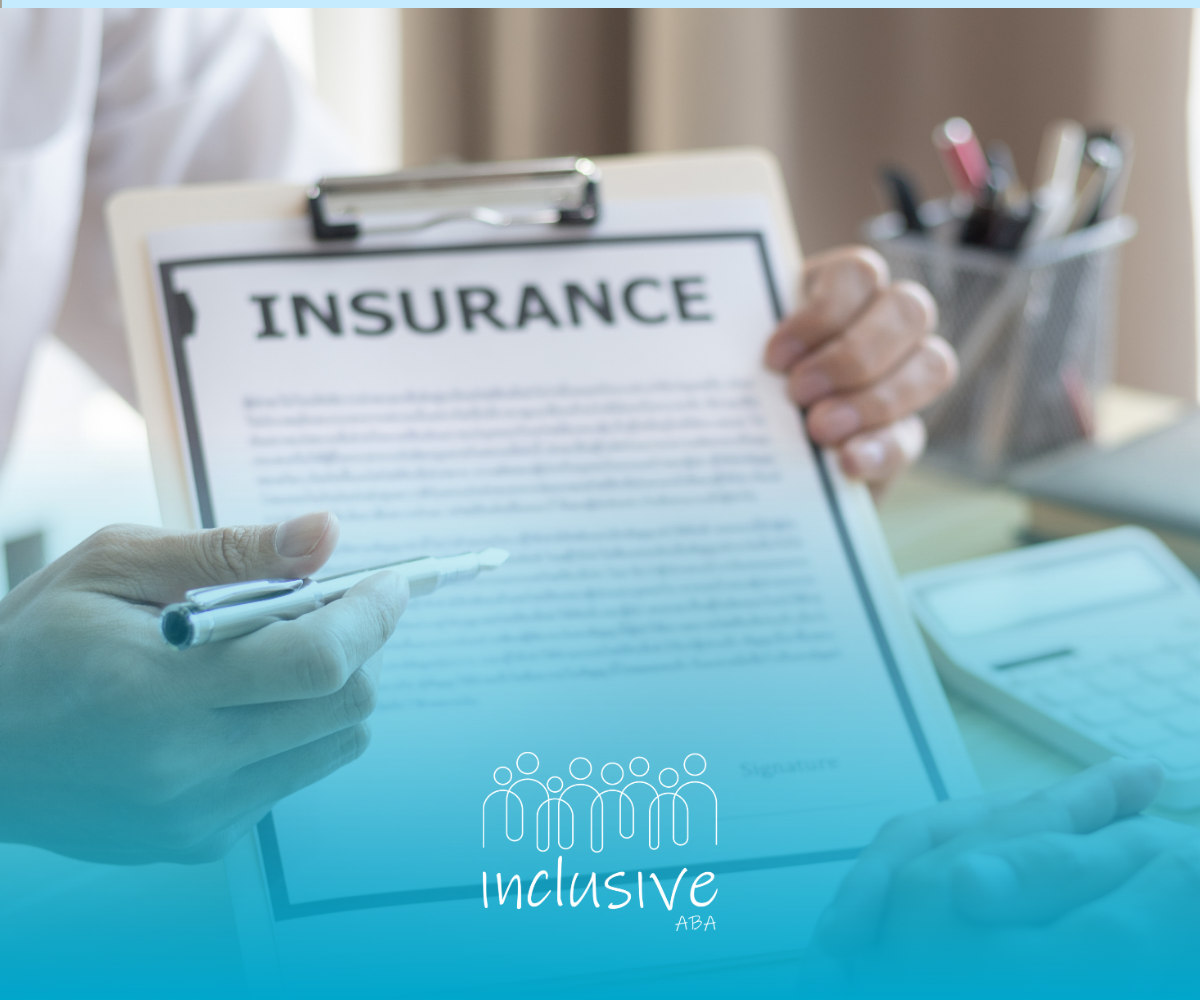 Clipboard labeled “INSURANCE” held at a desk with a pen and office supplies in the background