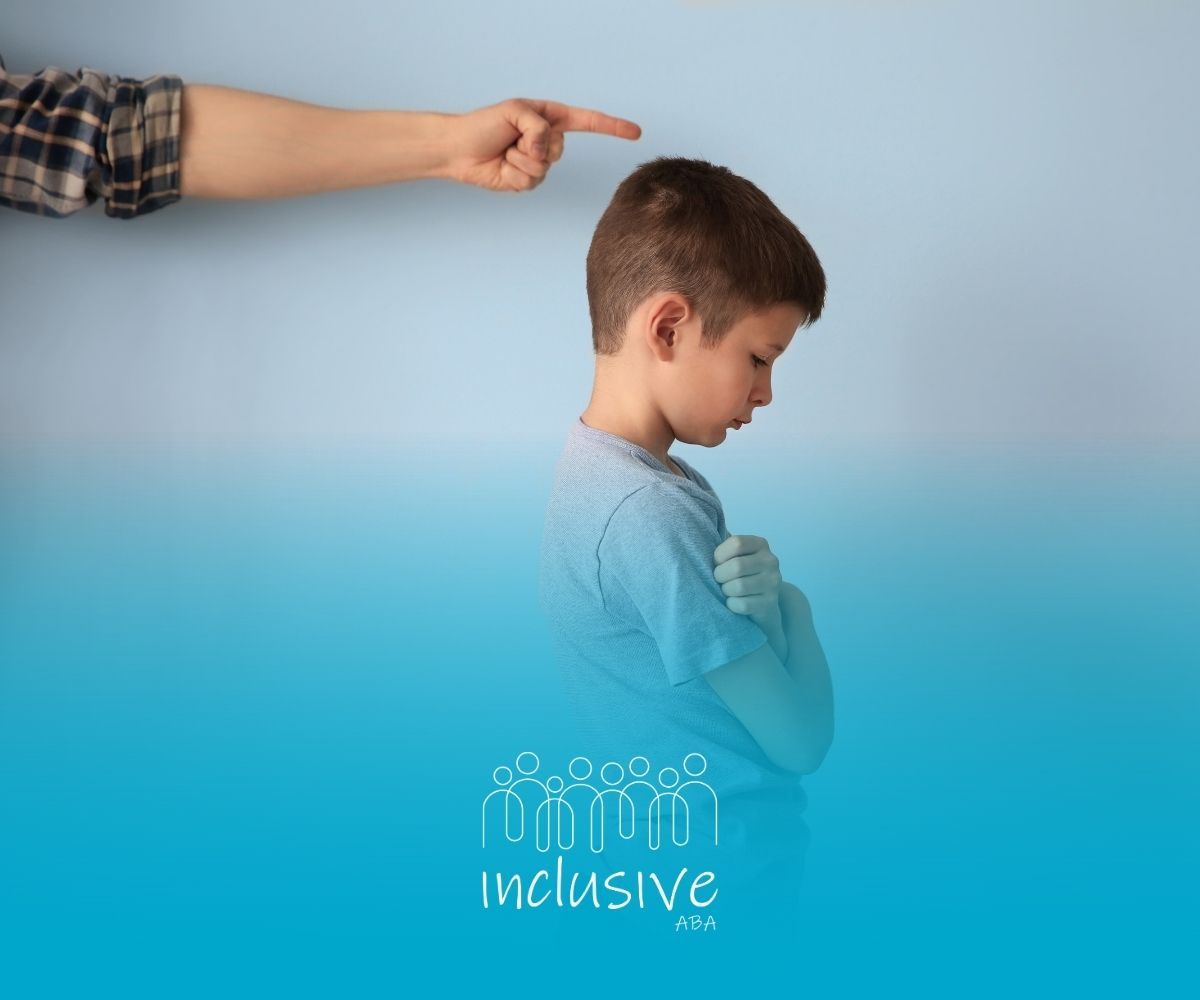 Person's hand pointing at a child with head down, arms crossed. Blue background,