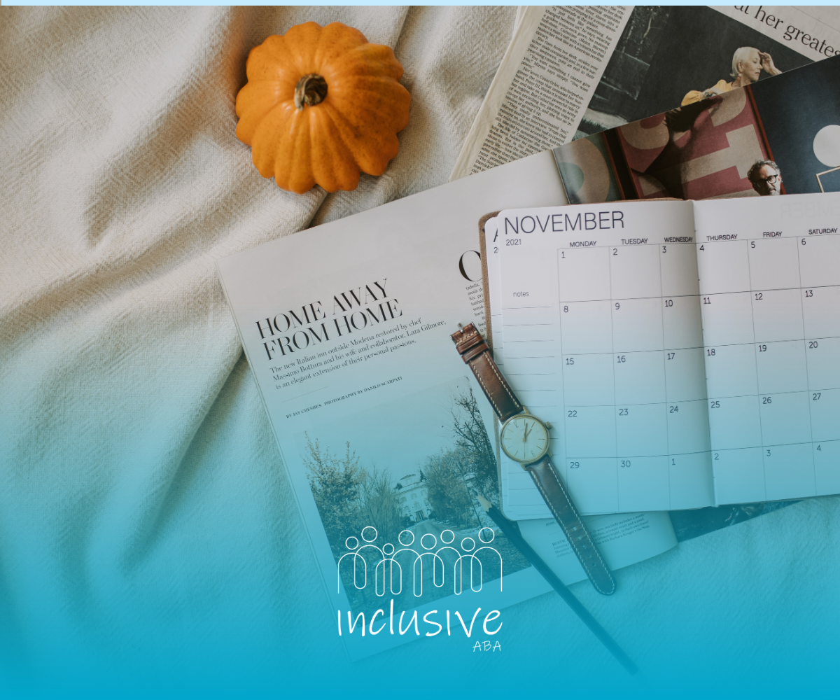 A planner, open book, candle, and orange pumpkin on a soft blanket with blue light overlay.