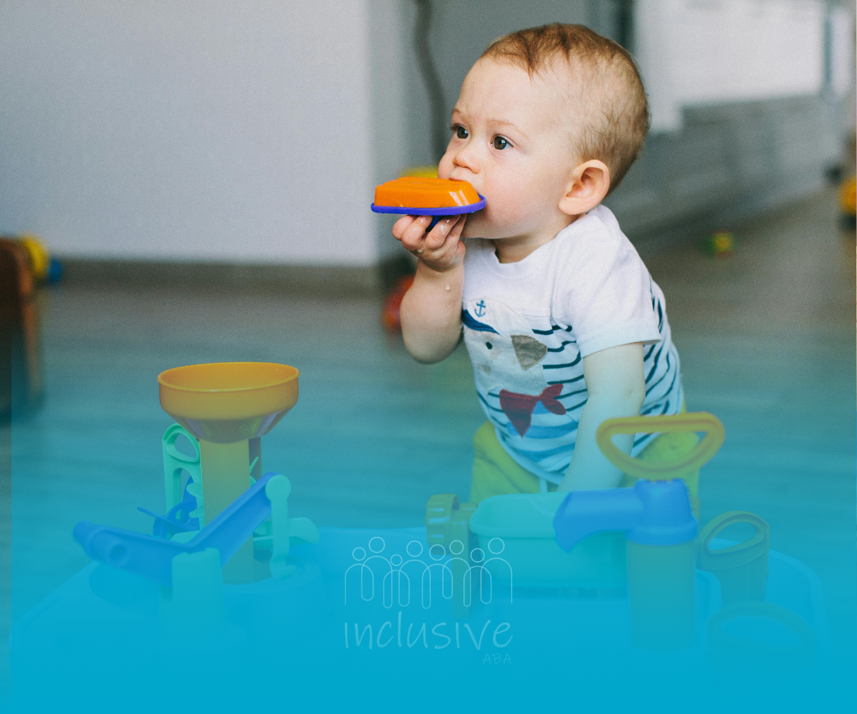 A baby is playing with a toy on a blue background.