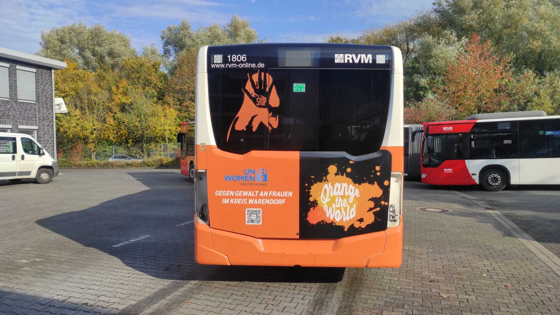 A bus is parked in a parking lot with other buses.