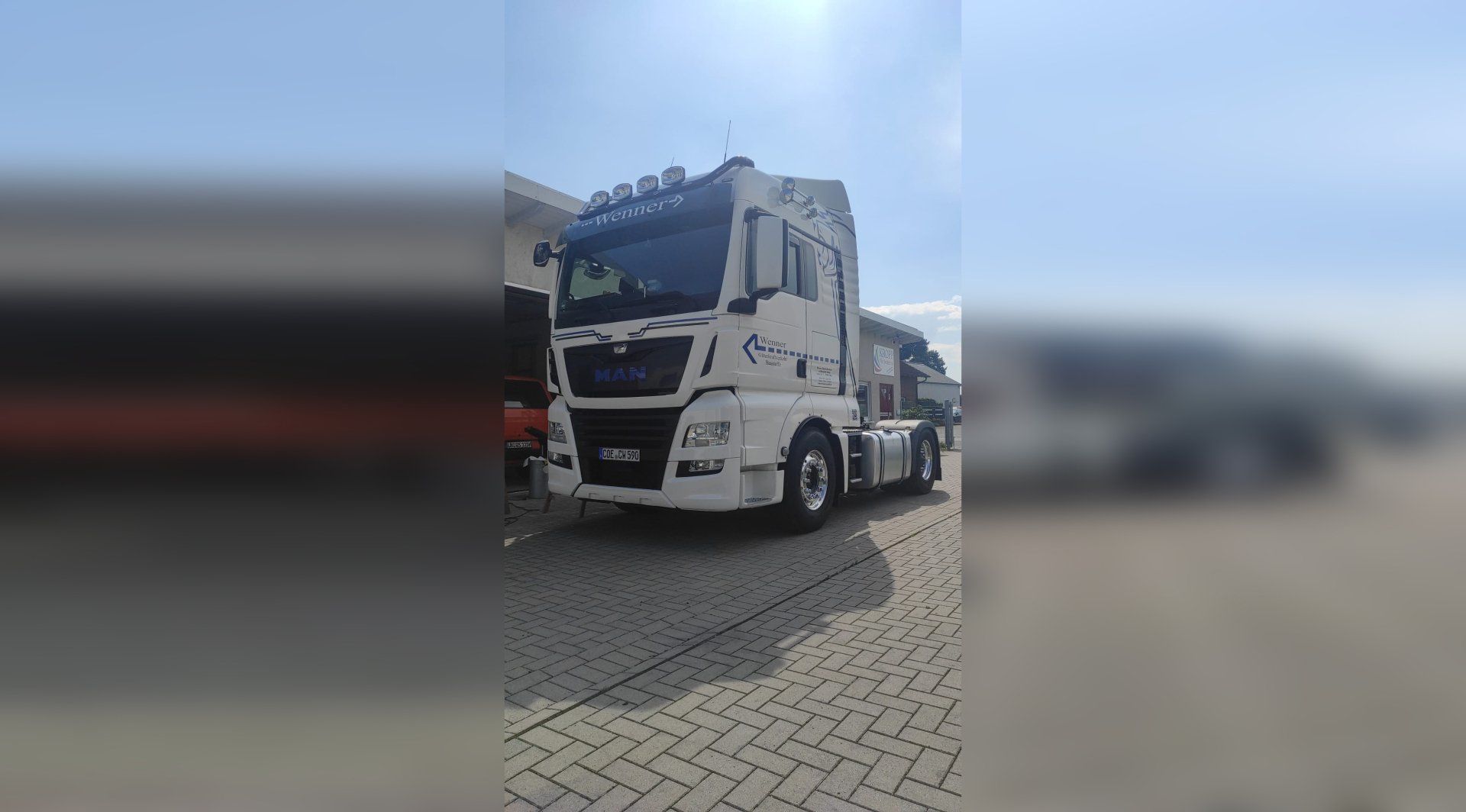 A white semi truck is parked in a parking lot.