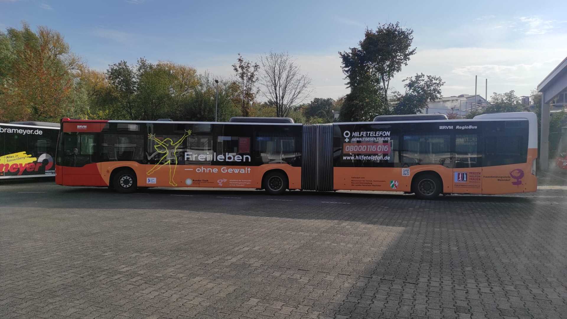 Two buses are parked next to each other in a parking lot.
