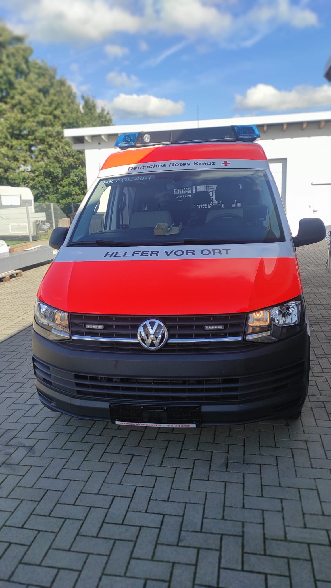 A red and white ambulance is parked in a parking lot.