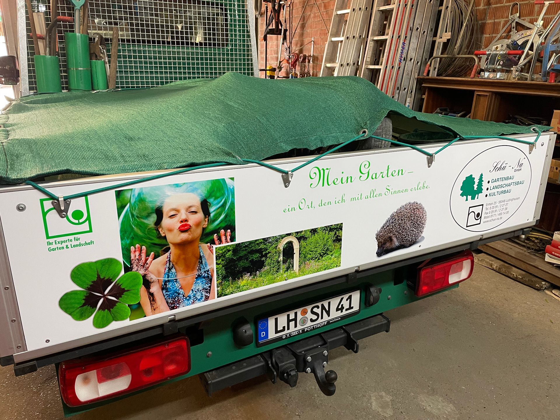 A green and white truck with a sticker on the back that says mein liebe