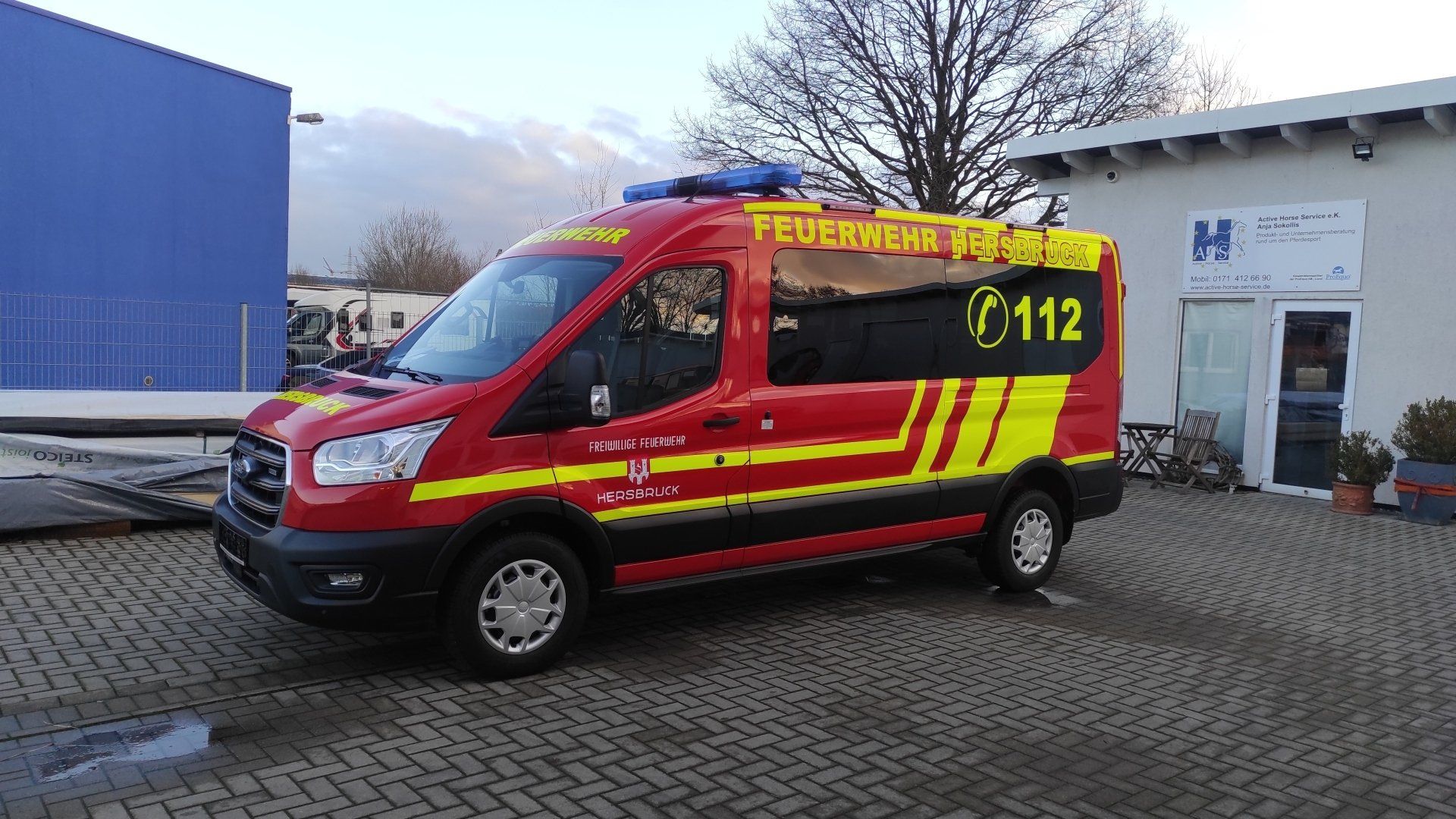 A red and yellow fire truck is parked in front of a building.