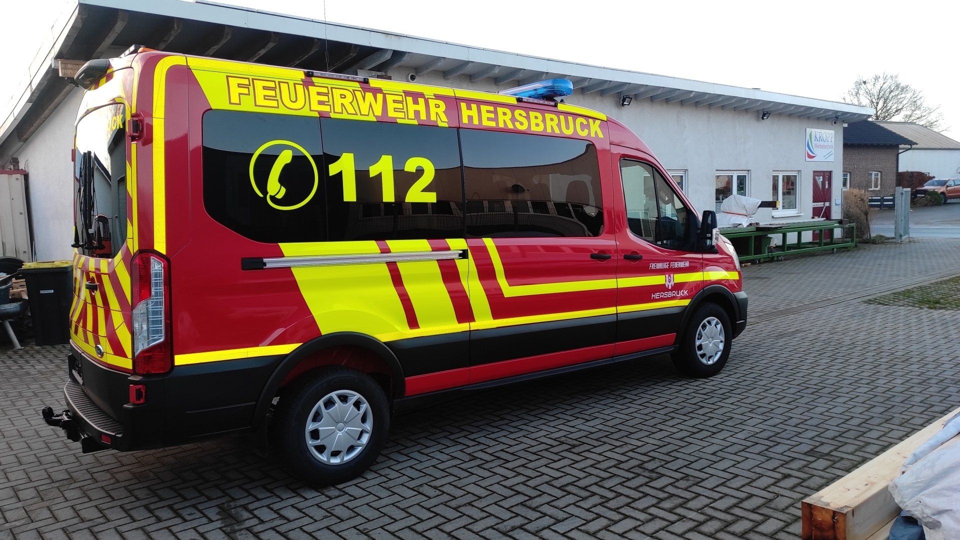 A red and yellow fire truck is parked in front of a building.