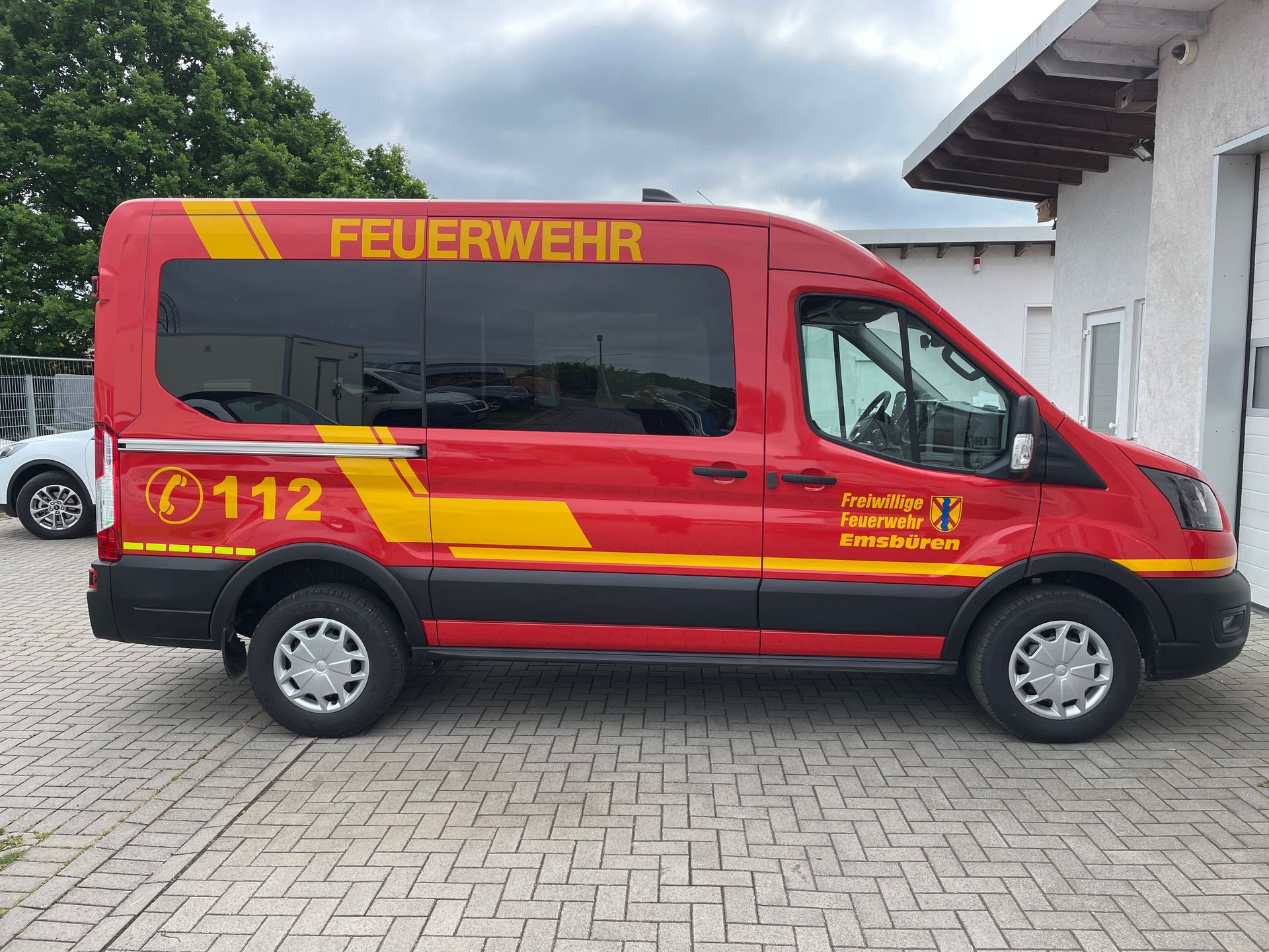 A red feuerwehr van is parked in a parking lot.