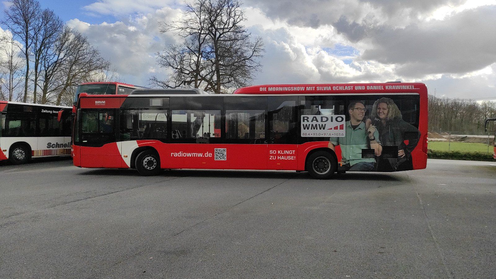 A red bus is parked on the side of the road.