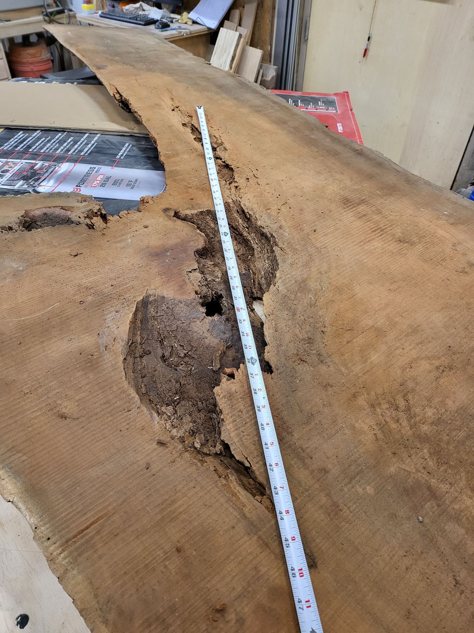 A measuring tape is laying on top of a piece of wood.