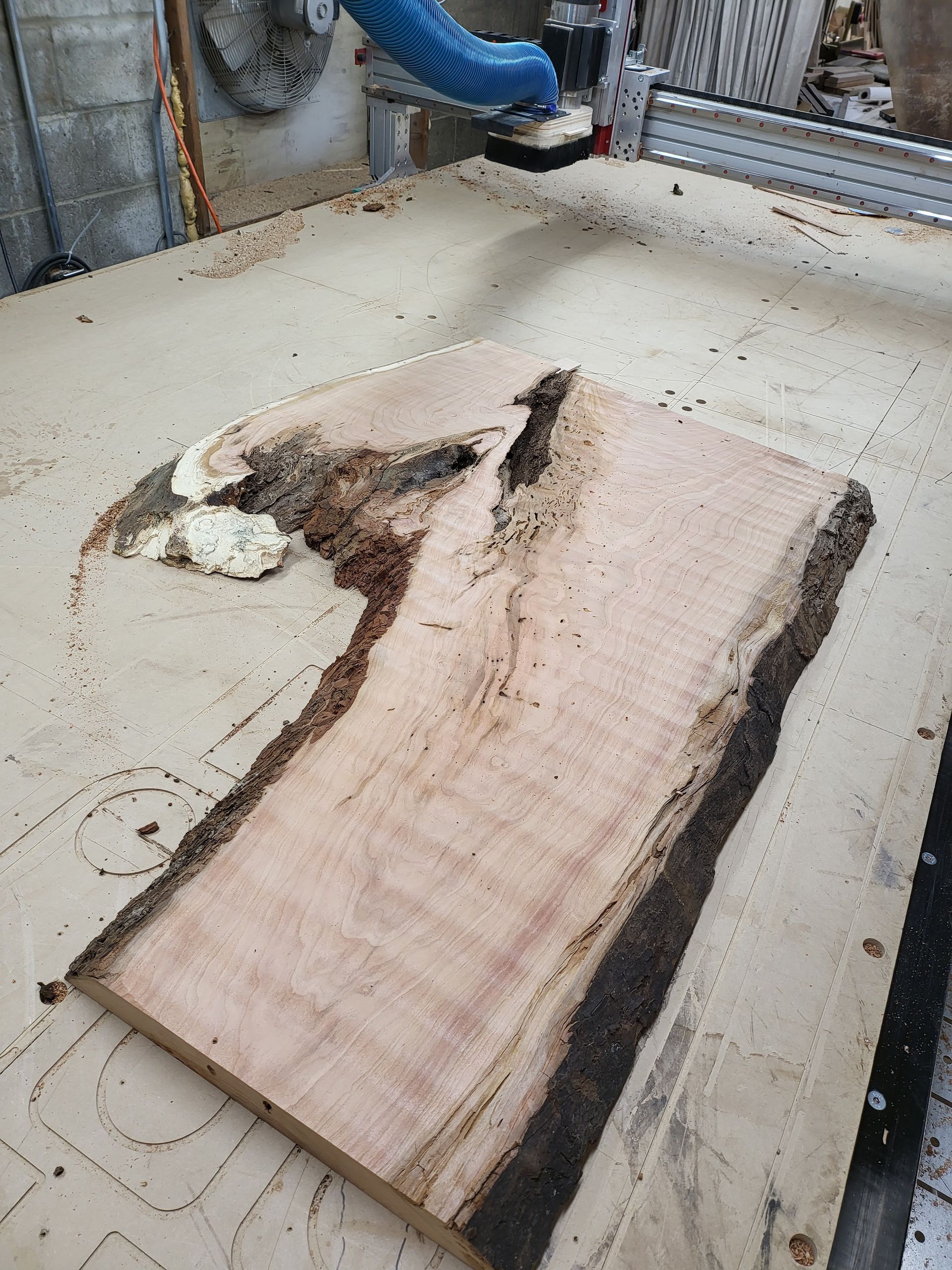 A piece of wood is being cut by a machine on a table.