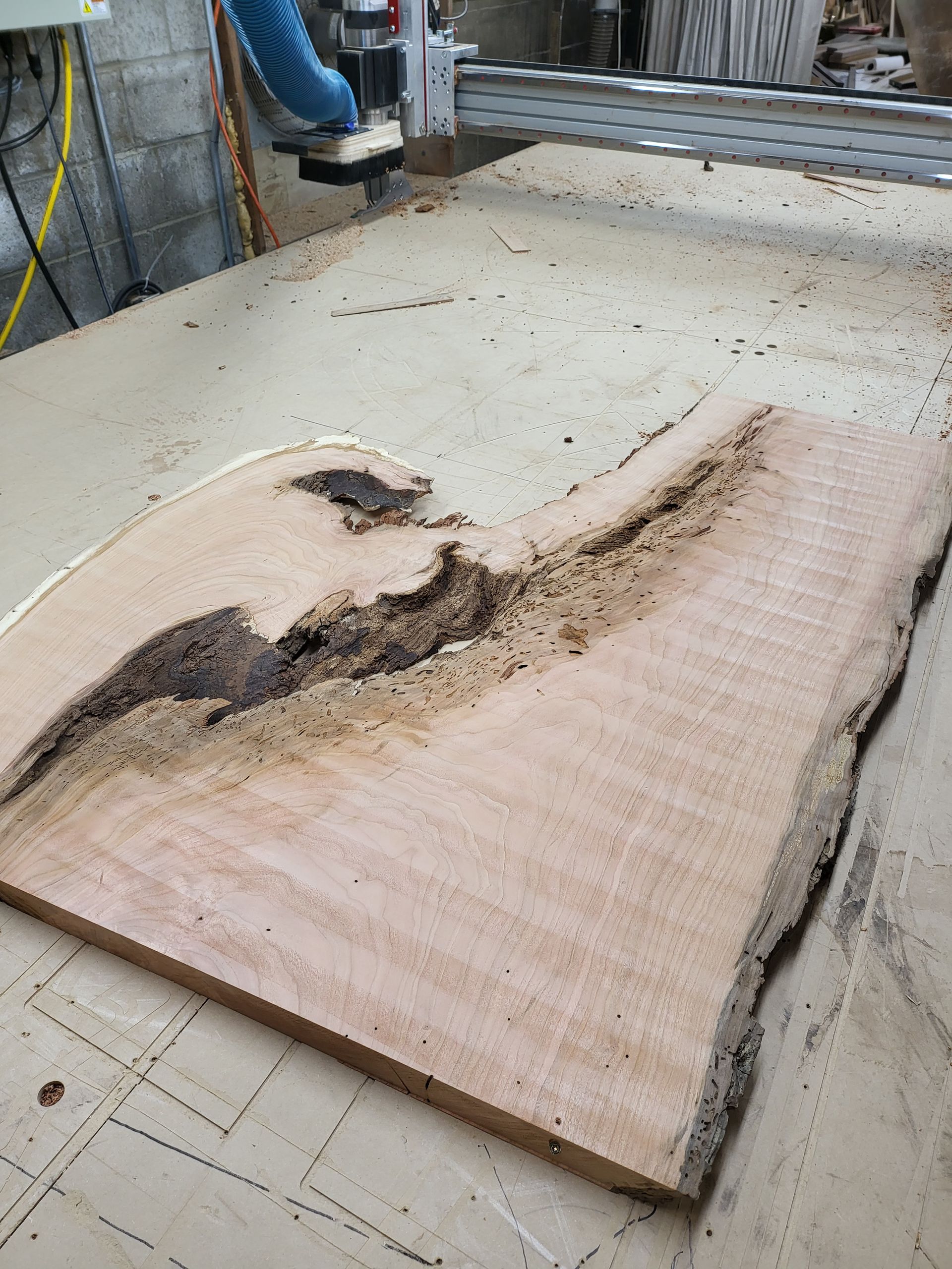A large piece of wood is being cut by a machine.