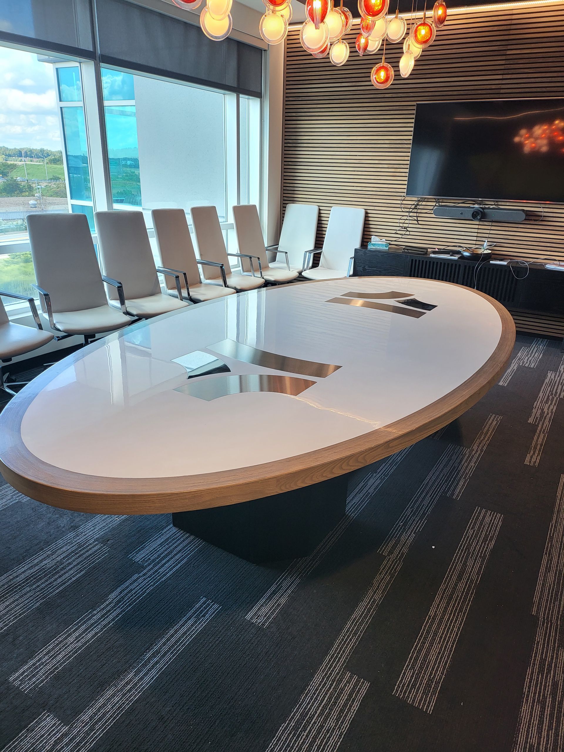 A conference room with a large oval table and chairs.