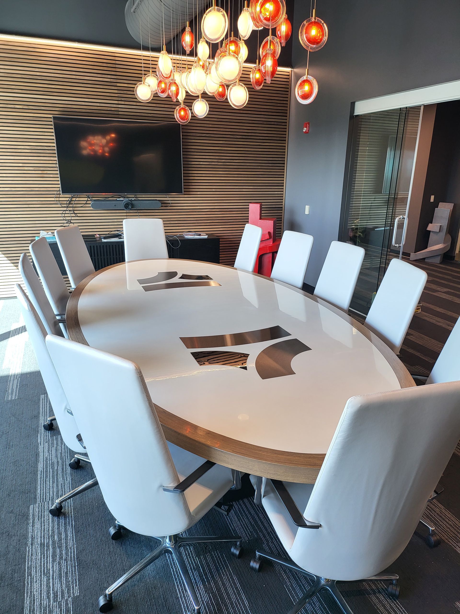 A conference room with a round table and white chairs