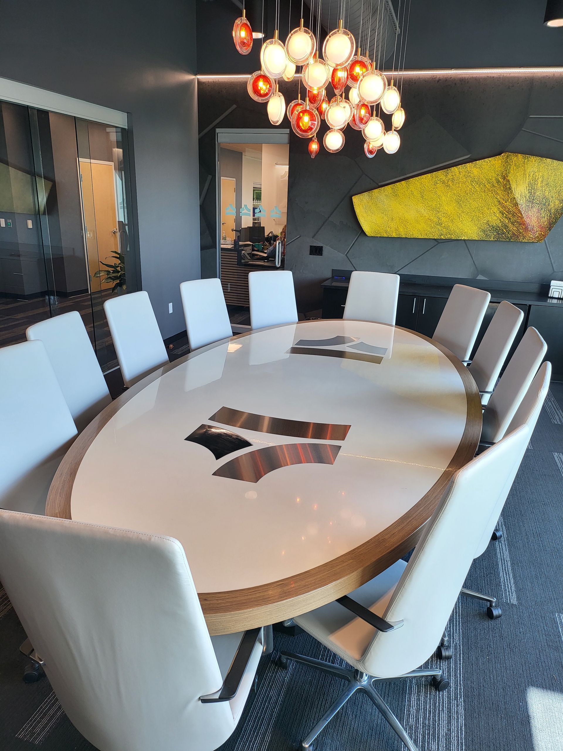 A conference room with a large oval table and chairs