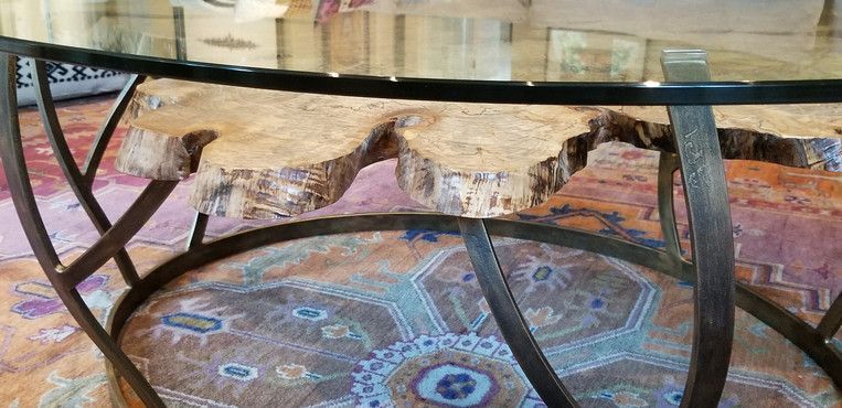 A coffee table with a glass top and a metal frame is sitting on a rug.