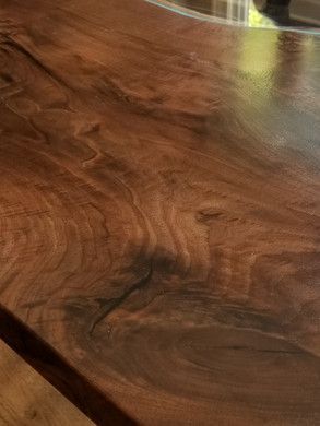 A close up of a wooden table with a glass top.