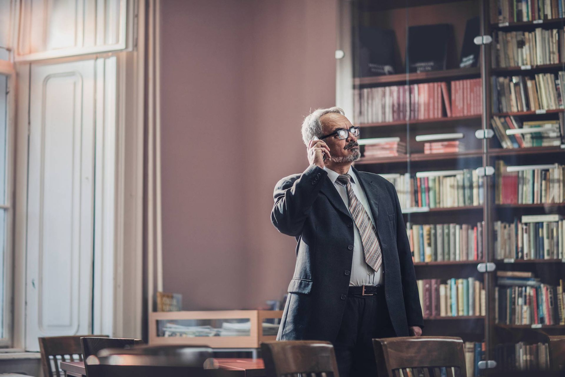 Mature Businessman Standing In His Office And Making A Phone Call On Cell Phone — New Braunfels, Texas — Ronald D. Zipp Attorney At Law Mature Businessman Standing In His Office And Making A Phone Call On Cell Phone — New Braunfels, Texas — Ronald D. Zipp Attorney At Law