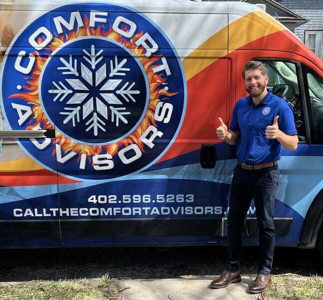 Man giving thumbs up next to a van. The van has the words 