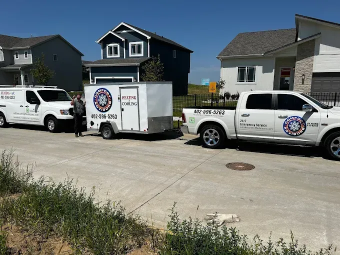 White vans and truck with trailer in a residential area, advertising