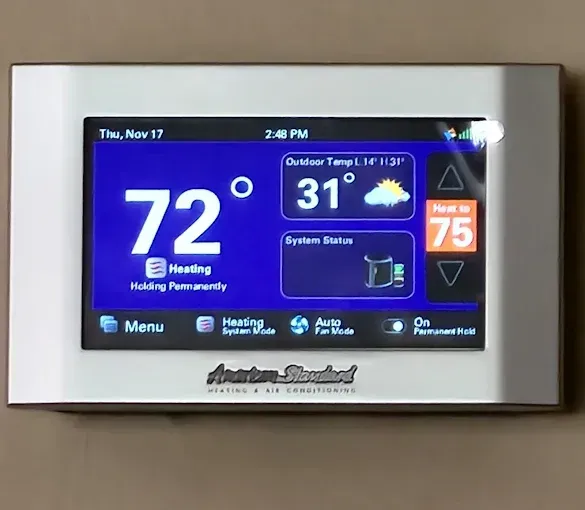 White thermostat displays 72 degrees, outdoor temp 31 degrees, heating, and menu options.