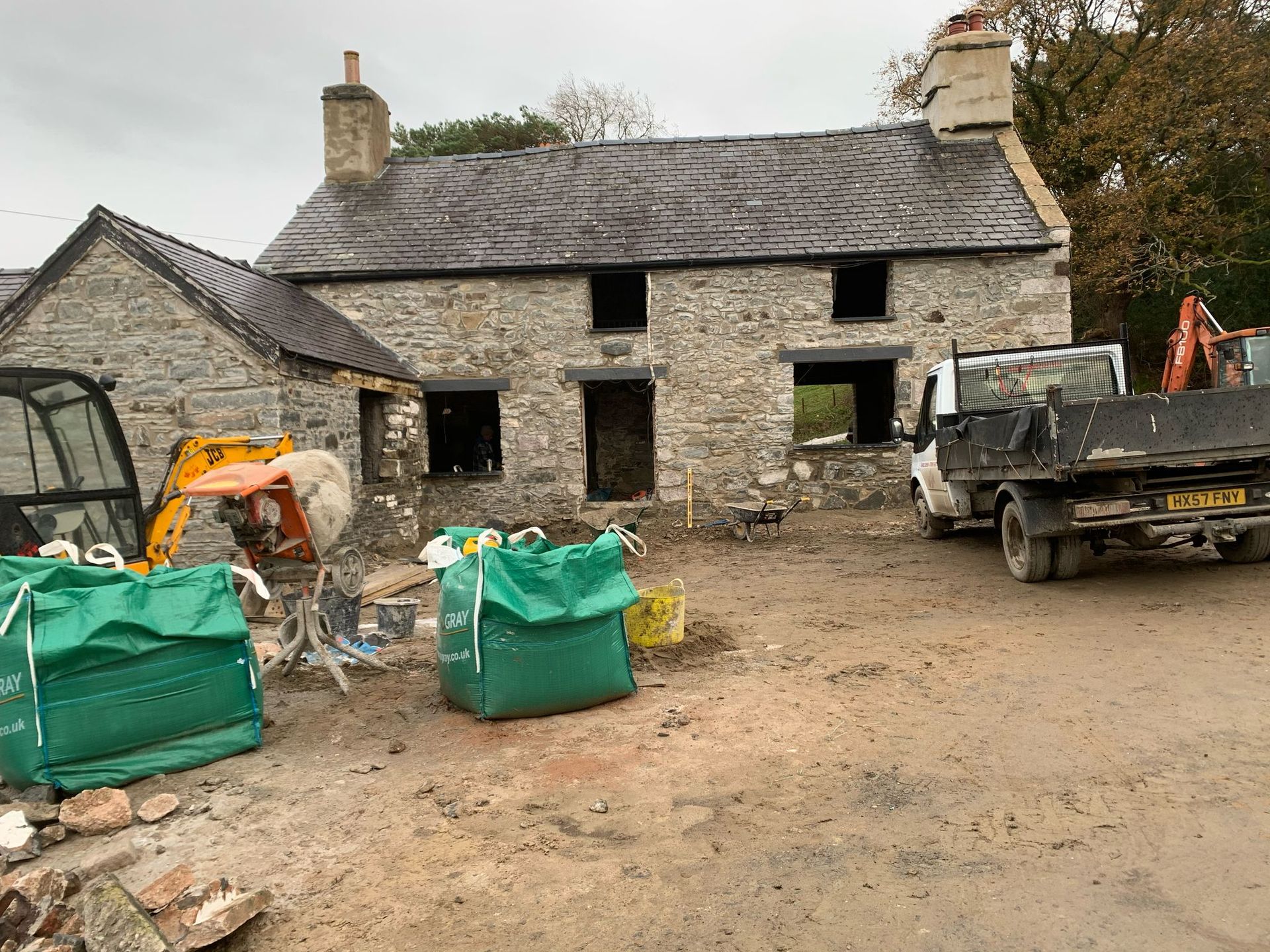 A truck is parked in front of a stone house.