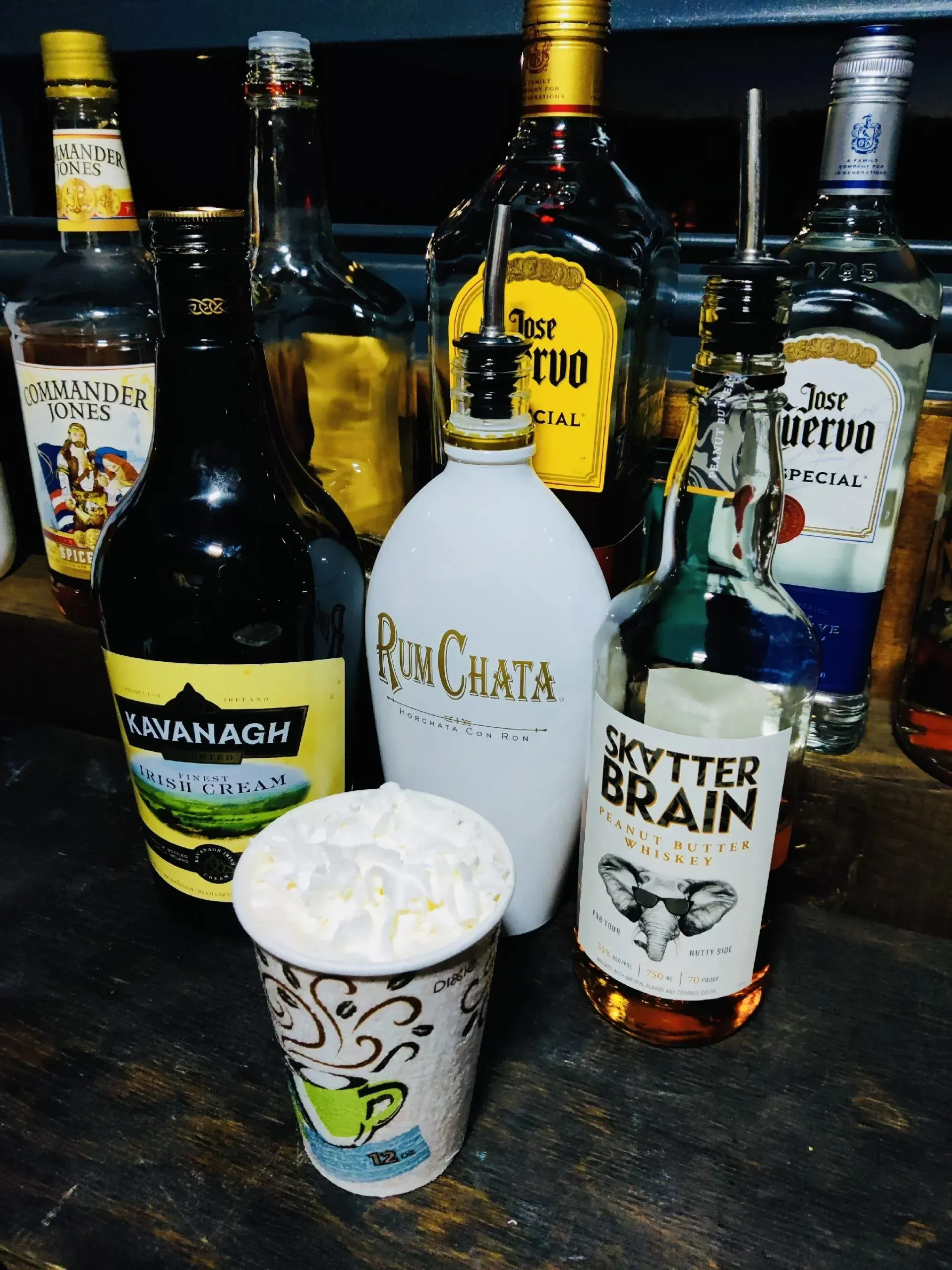 A bottle of skytter brain is next to a cup of whipped cream