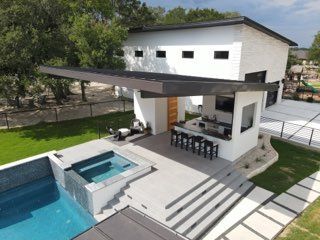 Modern house patio with pool, hot tub, and shaded outdoor bar area