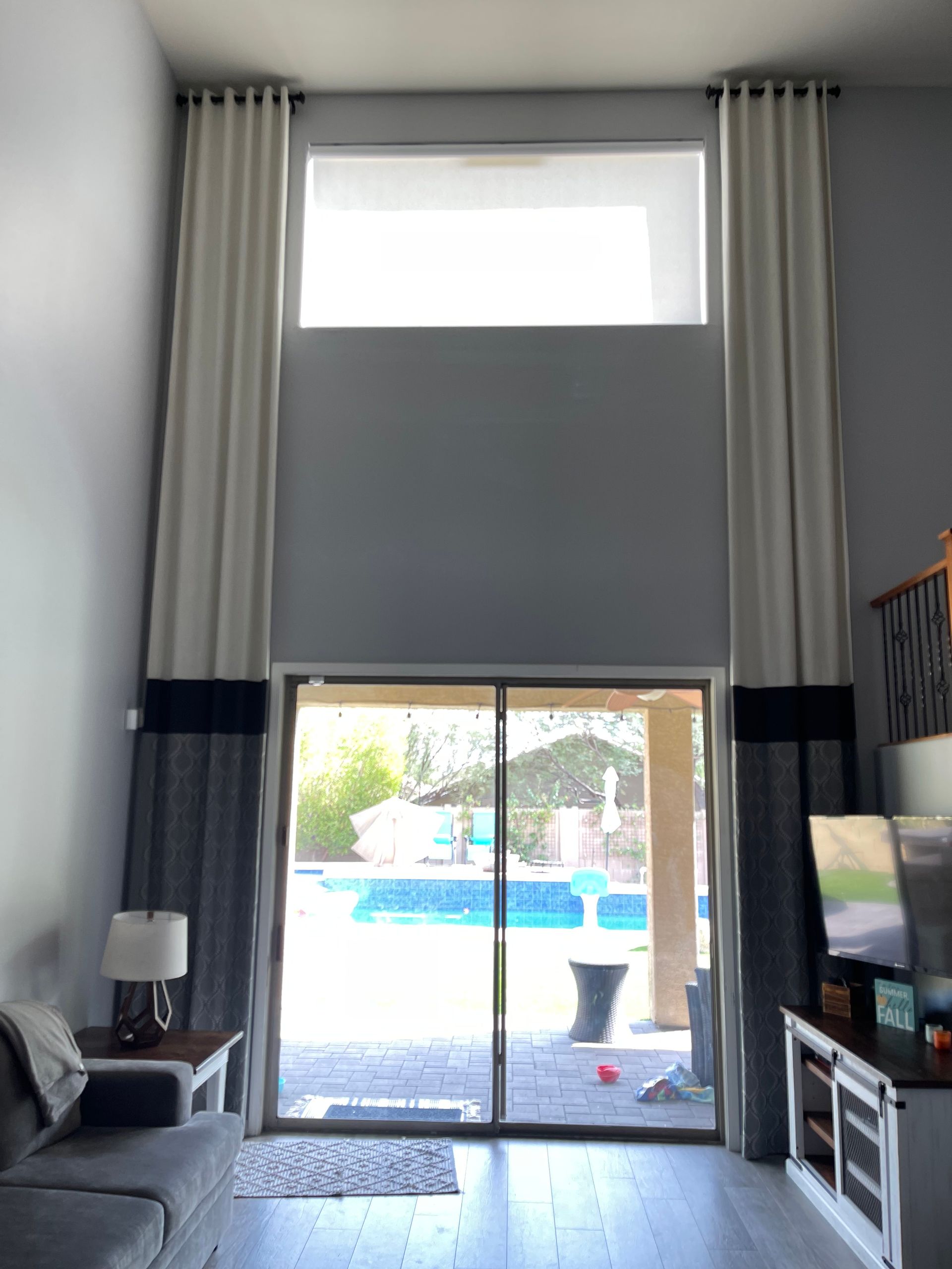 A large window with drapes and blinds covering part of it