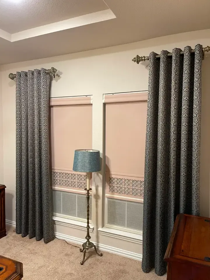 Laser cut blinds that are closed with curtains to the sides of a window