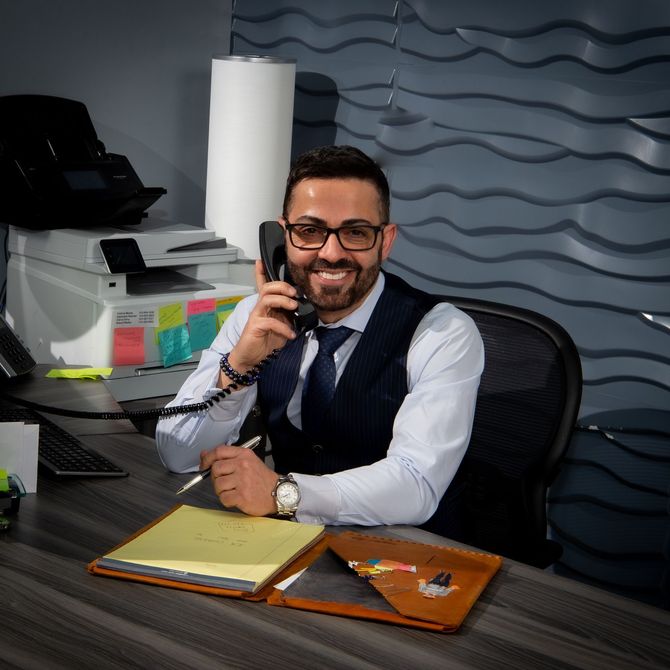 Smiling office worker on the phone at a desk with a folder and papers in a modern office