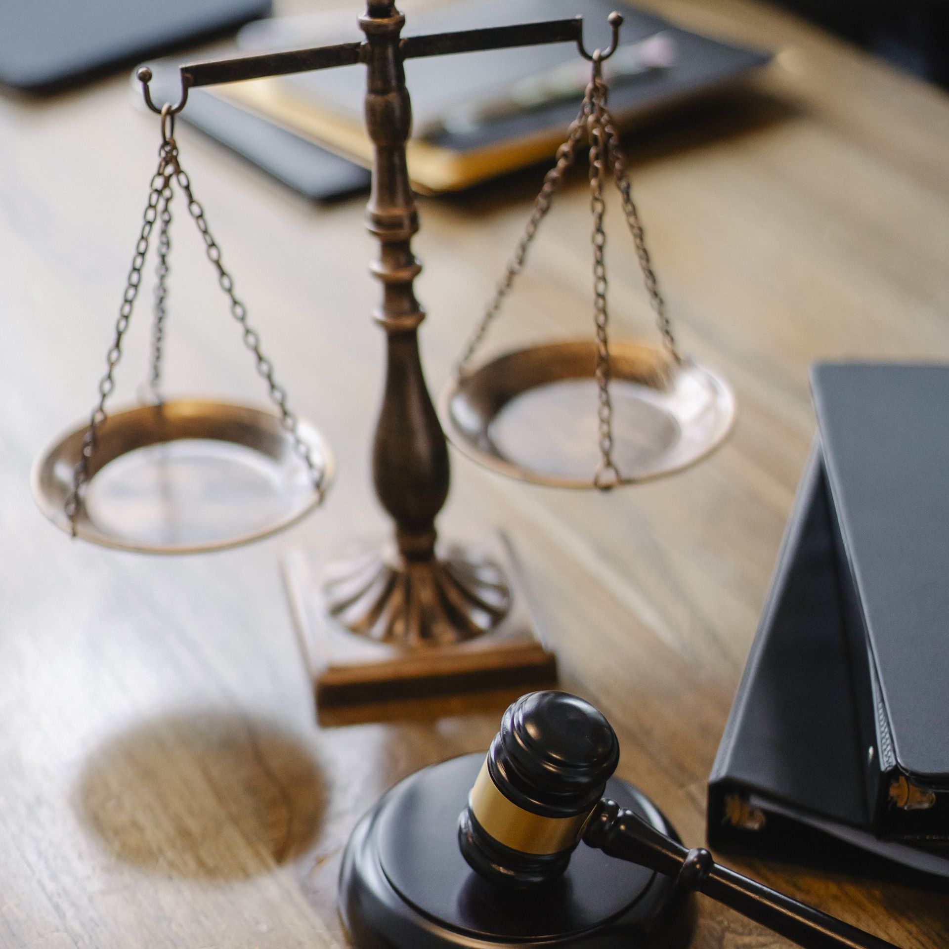 Lawyer’s desk with scales of justice, gavel, and binder on a wooden table