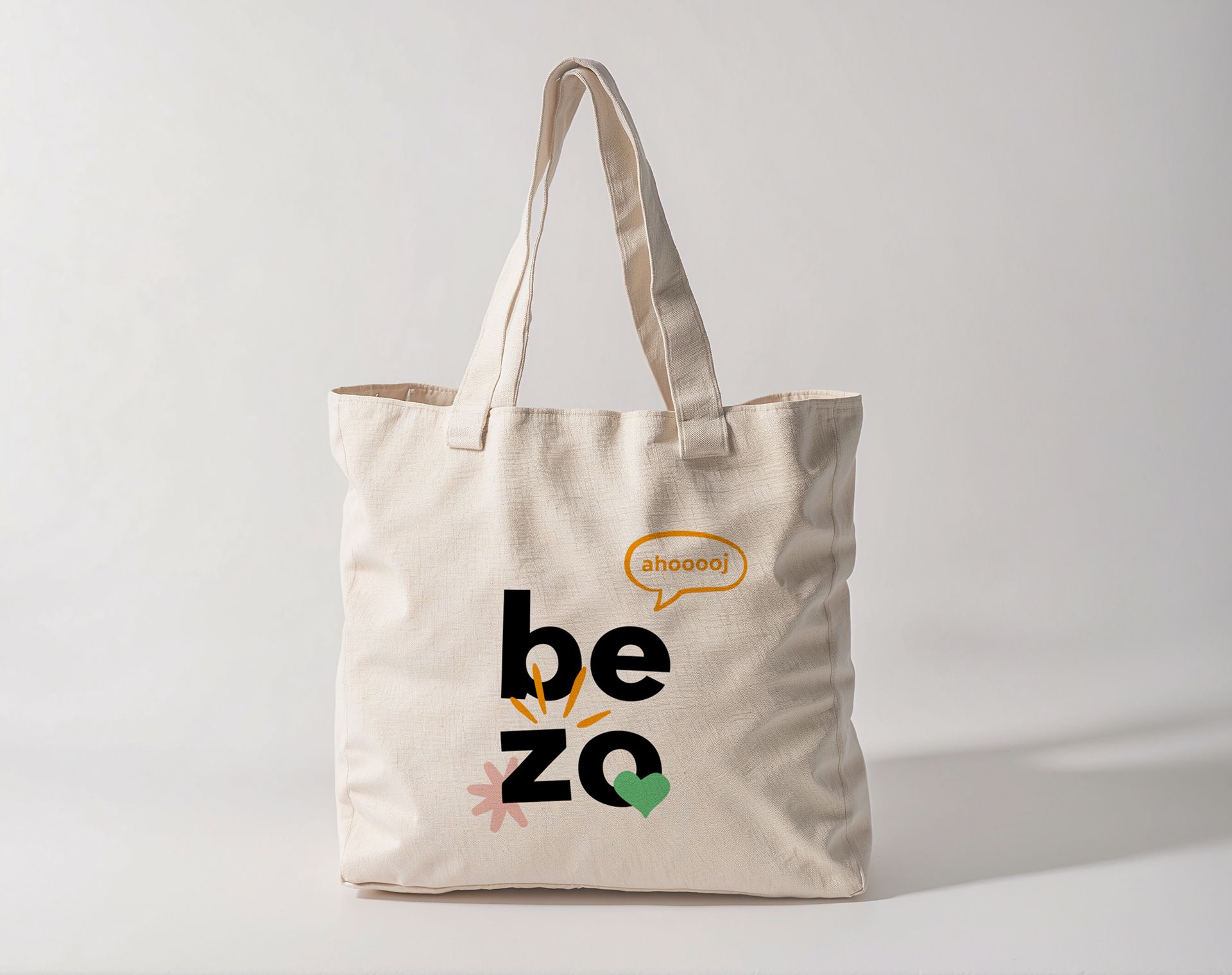 Béžová taška s černým a zeleným nápisem „be zo“ na světlém pozadí