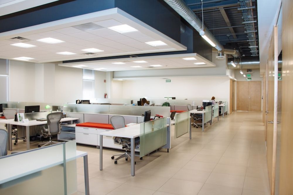 A large empty office with lots of desks and chairs.