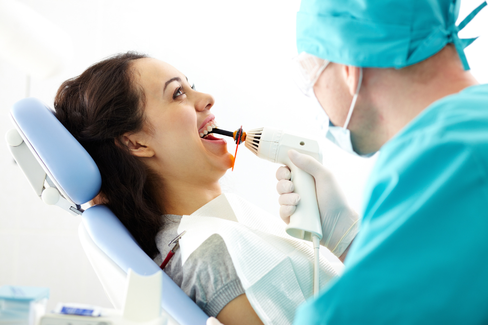 A woman is getting her teeth examined by a dentist.