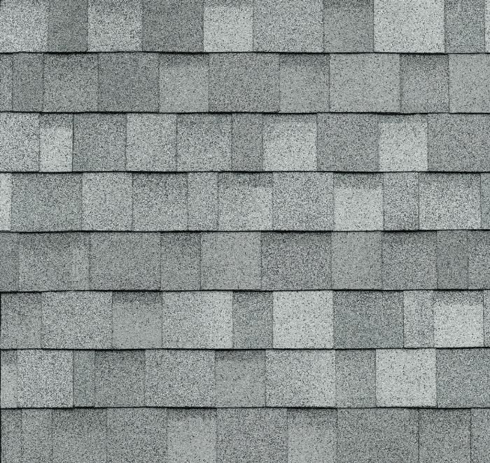 Bardeaux de toiture en asphalte gris, disposés selon un motif rectangulaire répétitif.