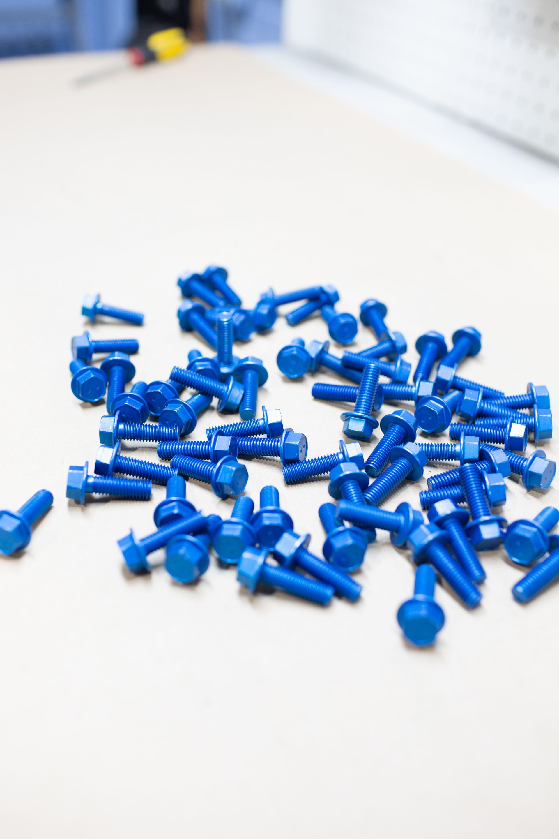 A pile of blue screws illustrating LMC’s anodizing and metal finishing process.