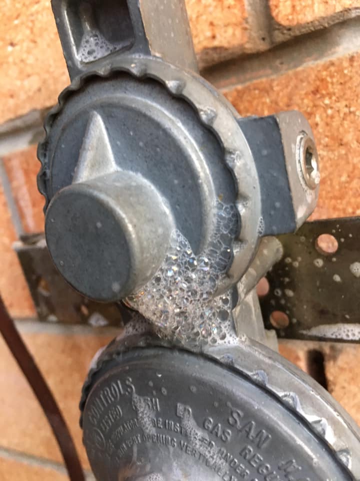 Soapy bubbles on a propane gas regulator, likely indicating a leak — Gas Fitting Services in Bundaberg, QLD