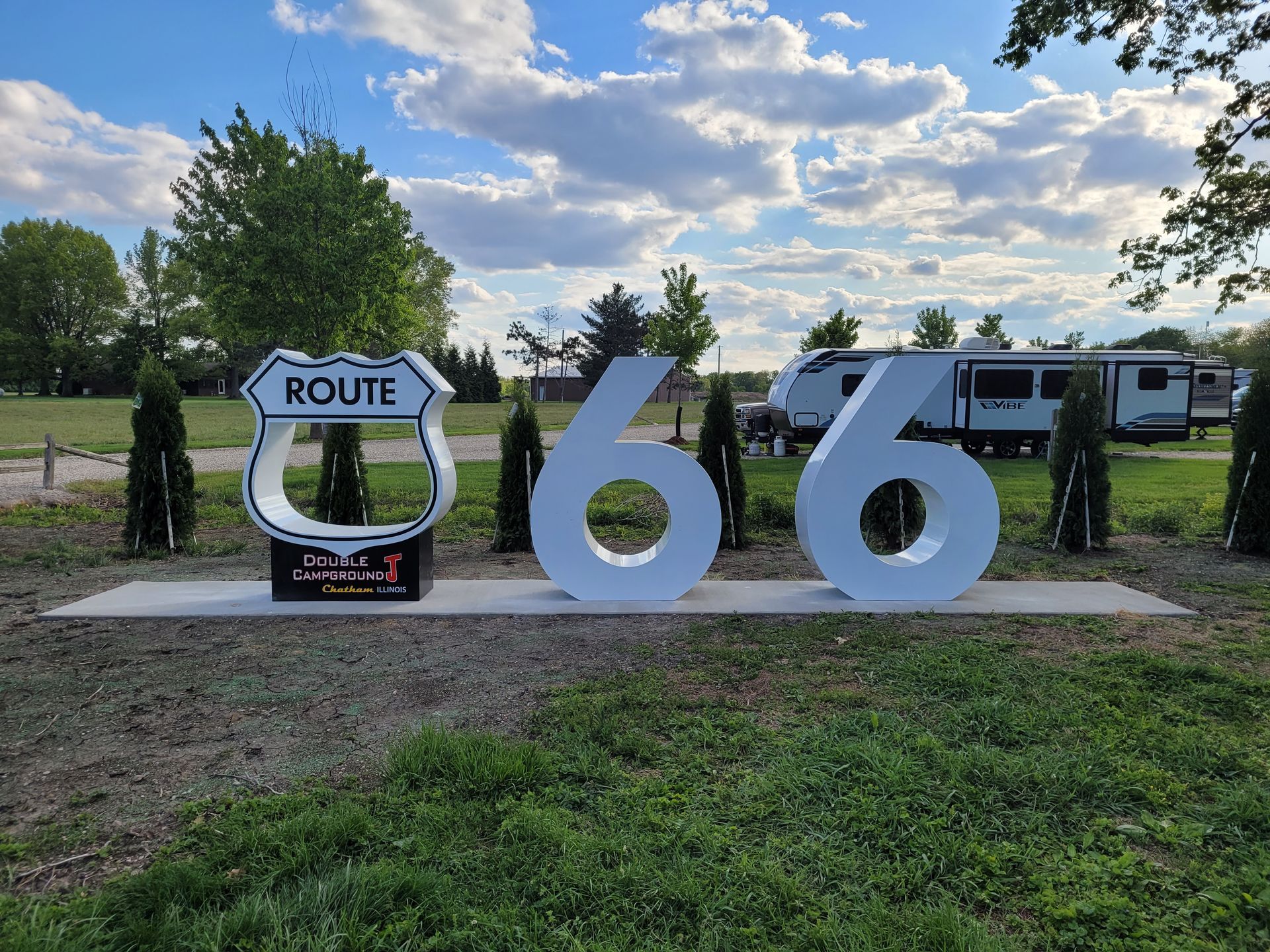 A white bench in front of a historic route 66 sign