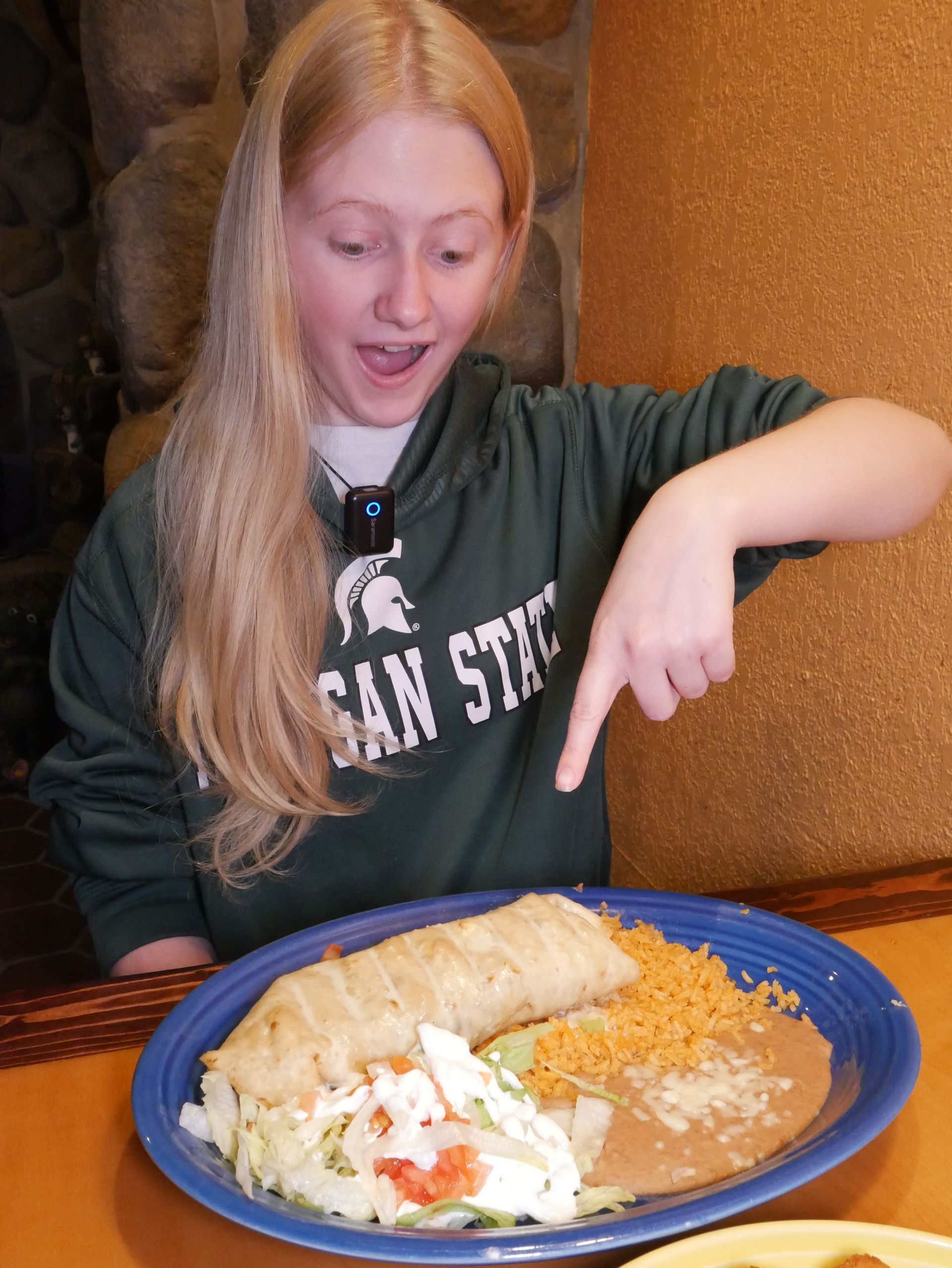 MSU student enjoying a large burrito plate at Fiesta Charra Eastwood in Lansing
