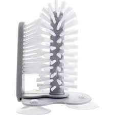 Image of cleaning brush with white bristles and suction cups on its base.