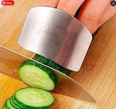 Image of silver finger guard attached to fingers, cutting a cucumber.