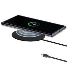 Black and silver phone charger pad holding a black smart phone on top.