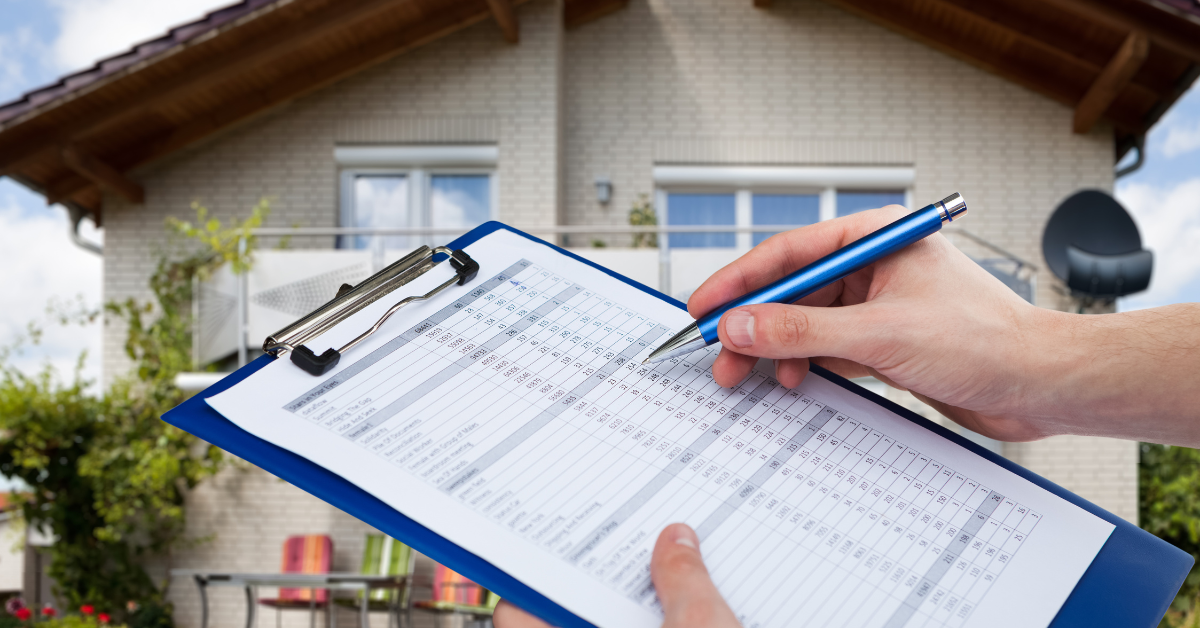 A person is writing a home inspection report on a clipboard.