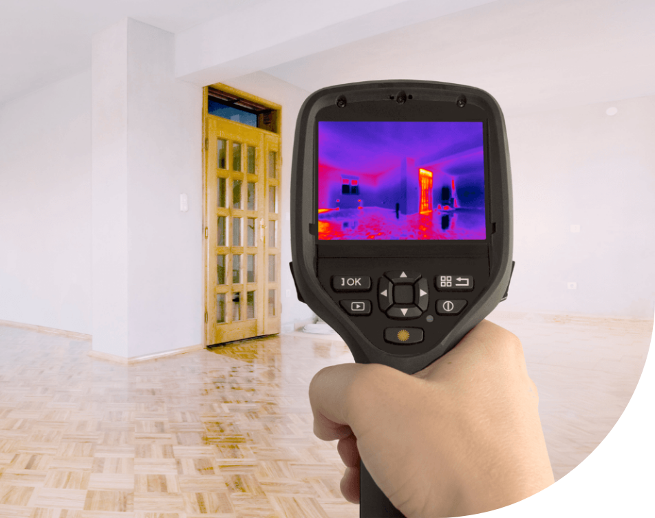 A person is holding a thermal camera in a room.