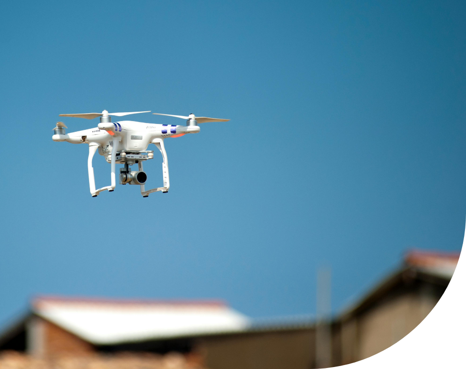 A drone is flying in the sky over a building.