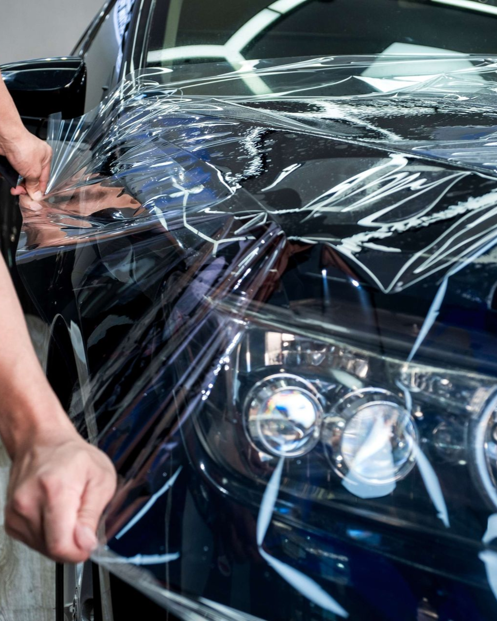 A person is washing a car wheel with foam
