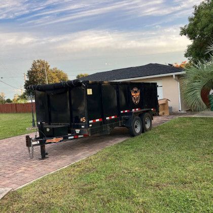 A dumpster trailer is parked in front of a house.