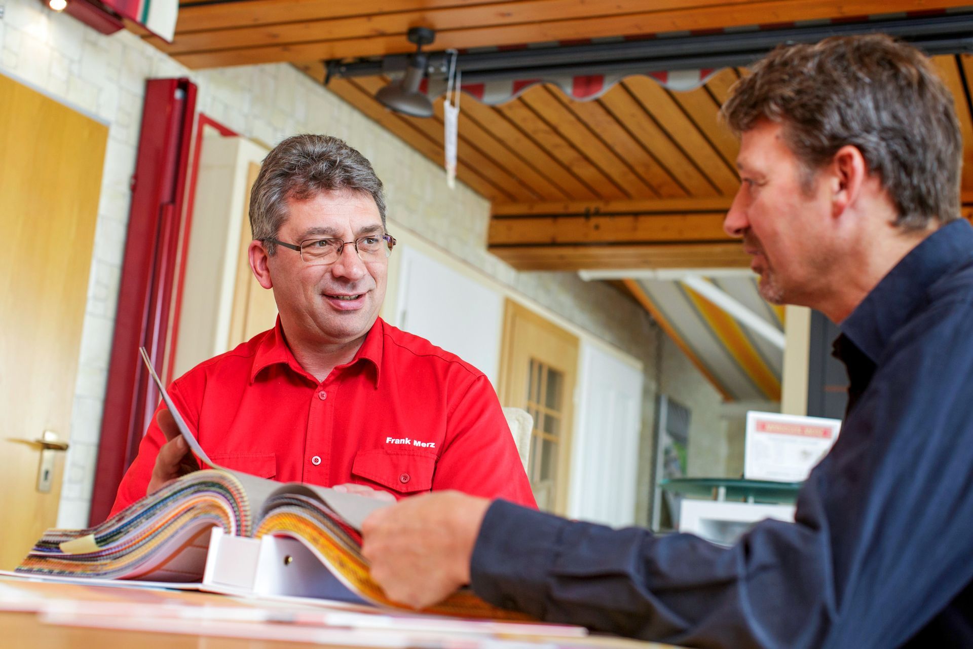 Frank Merz und Kunde sitzen an einem Tisch und Kunde wird beratet