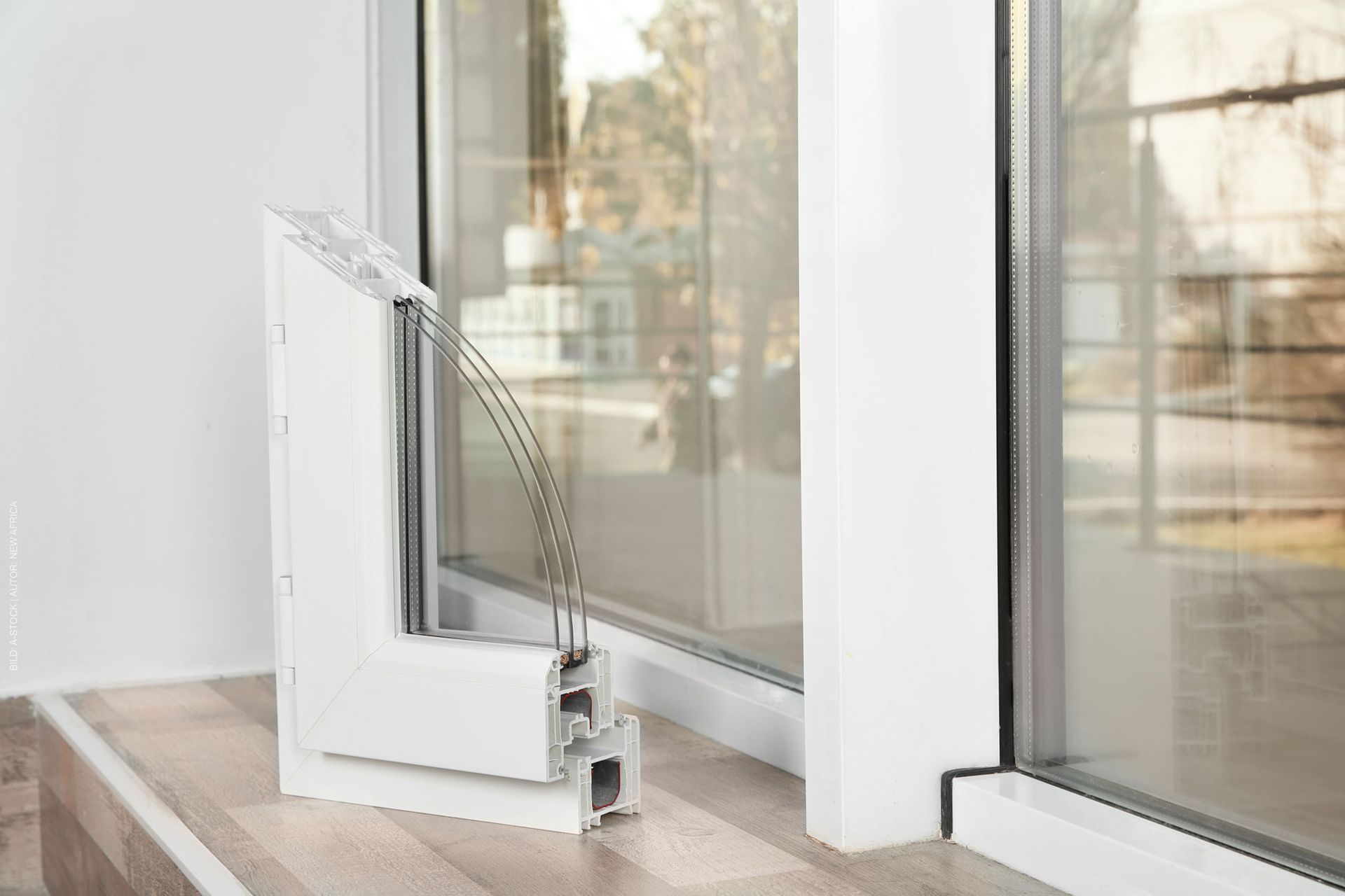 In einem Raum befindet sich auf einem Holzboden eine Glasschiebetür. Fensterprofile von Terrassenwelten Frank Merz